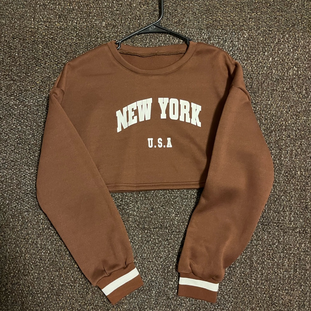 A brown cropped sweater with the logo New York